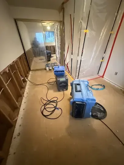 Plastic containment, a dehumidifier and an air scrubber drying a stripped hallway