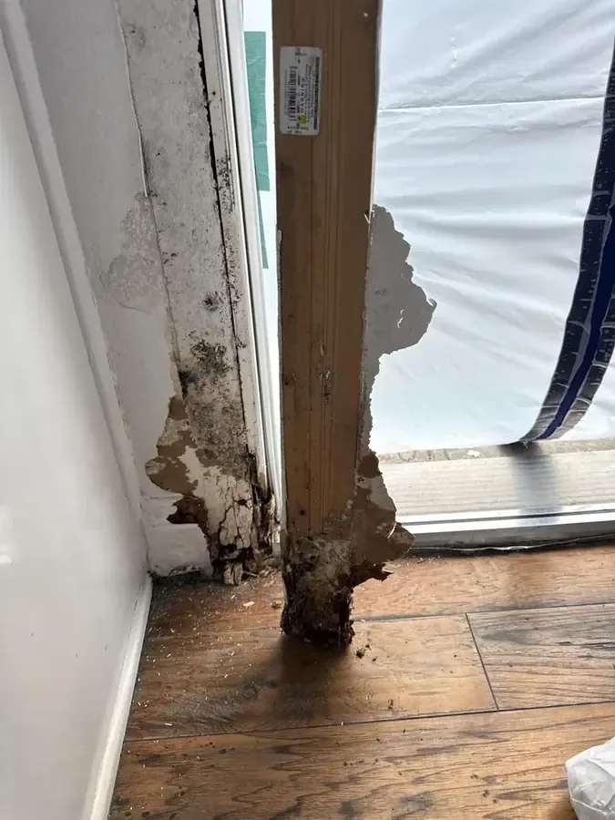 A corroded pipe leak traced at the base of a wall