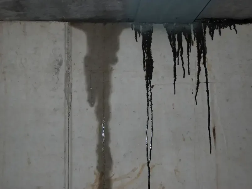 Rain water running down a concrete wall after a winter storm