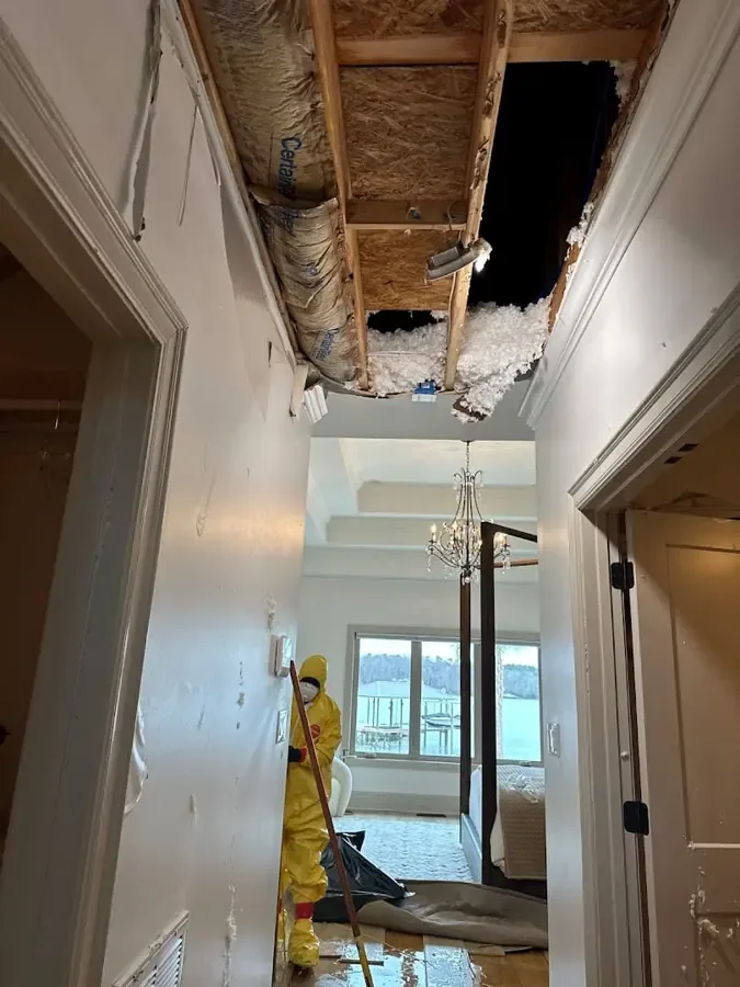A brown water stain spreading across a ceiling from a leak above